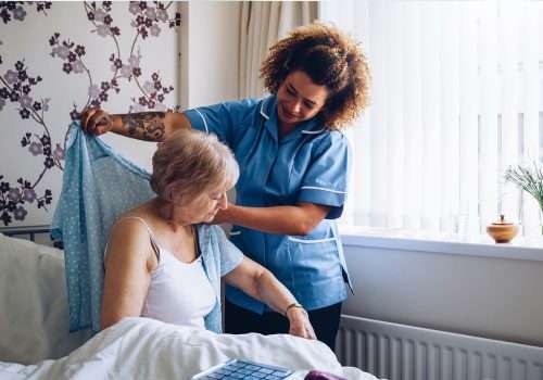 Carer helping an older woman get dressed