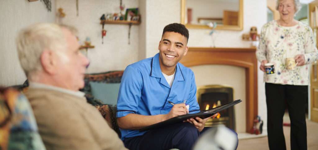 Care assessor smiling while taking notes during a home visit