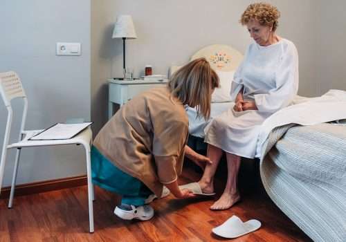 Carer helping an older woman put on her shoes